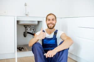 Handsome plumber at the kitchen